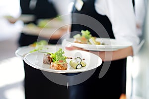 Waiter carrying plates with meat dish