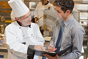 Waiter and chef discussing the menu