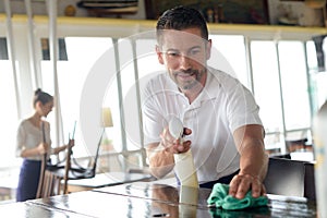 waiter cleaning countertop with sponge