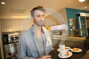 Waiter at the coffee shop serving