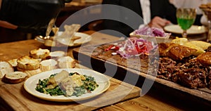 The waiter cuts the finished meat and runs the table in the restaurant