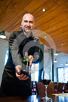 Waiter holding a bottle of red wine