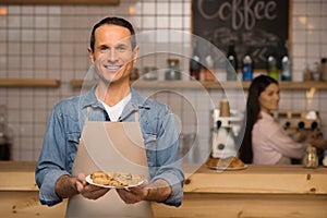 Waiter holding croissants on the plate