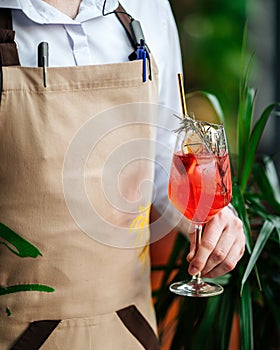 Waiter holding a glass of fancy cocktail