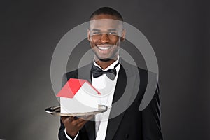 Waiter Holding House Model In Tray