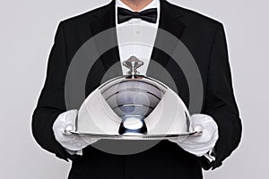 Waiter holding a silver cloche photo