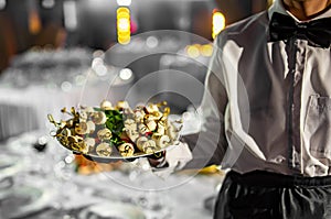 Waiter holds tray with food. Restaurant service