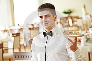 Waiter man with tray at restaurant photo