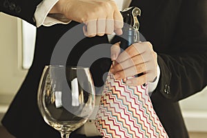 Waiter opens a bottle of wine in restaurant at the table,festive dinner,service