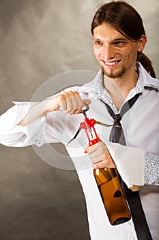 Waiter opens wine bottle.