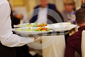 waiter with plate with food in the hands