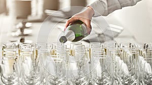 Waiter pouring champagne into glasses at party