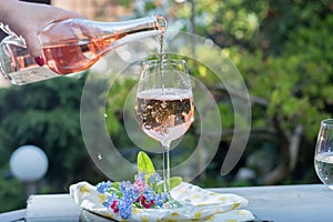Waiter pouring a glas of cold rose wine, outdoor terrase, sunny