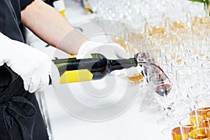 Waiter pouring glass of wine during catering service