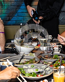 Waiter pouring wine to the glass