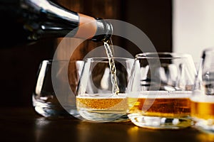 Waiter pouring wine into wineglass. Sommelier pours alcoholic drink.