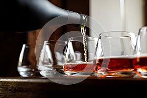 Waiter pouring wine into wineglass. Sommelier pours alcoholic drink.