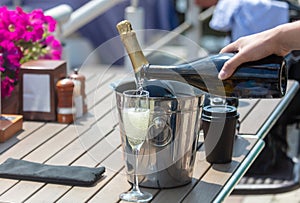 The waiter pours a glass of champagne