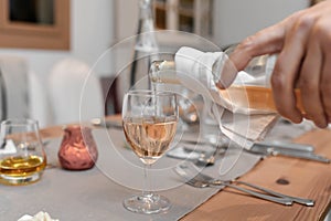 A waiter pours the pink french wine into the glass