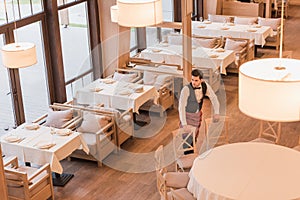 Waiter putting chairs around table