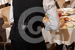 a waiter in a restaurant with a radio on his belt