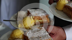 The waiter's hands hold plates of dessert, mouth-watering cakes with ice cream for the celebration of the event.