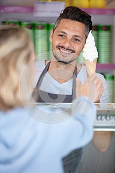 waiter selling ice cream cup at parlor