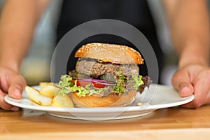 Waiter serves hamburger