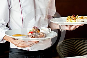 The waiter serves restaurant dishes