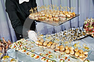 Waiter serving catering table