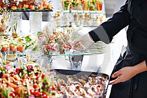Waiter serving catering table