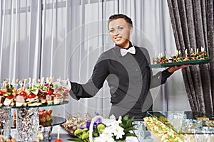 Waiter serving catering table