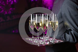 Waiter serving champagne on a tray