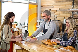 Waiter serving a cup of coffee to customer at counter