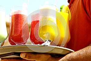 Waiter serving drinks. Cocktail on the beach