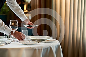 Waiter serving at an empty table