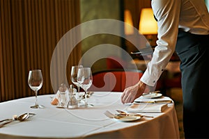 Waiter serving at an empty table