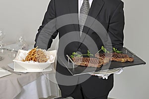 Waiter serving an entrecote