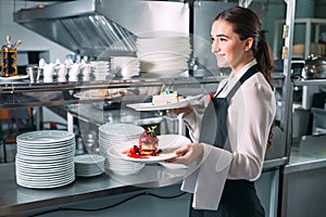 Waiter serving in motion on duty in restaurant. The waiter carries dishes.