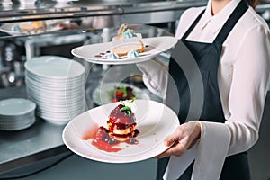 Waiter serving in motion on duty in restaurant. The waiter carries dishes.