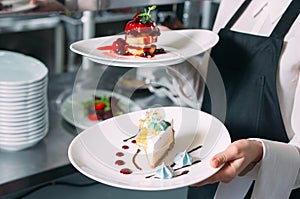 Waiter serving in motion on duty in restaurant. The waiter carries dishes.