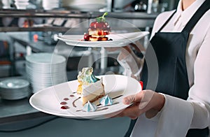 Waiter serving in motion on duty in restaurant. The waiter carries dishes.