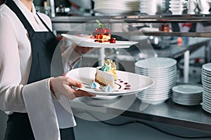 Waiter serving in motion on duty in restaurant. The waiter carries dishes.