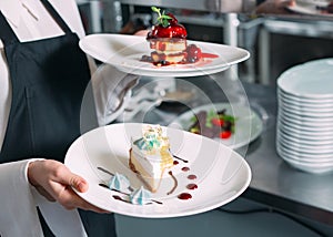 Waiter serving in motion on duty in restaurant. The waiter carries dishes.