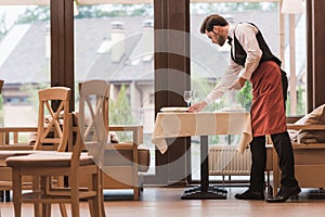 Waiter serving plates on table