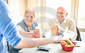 Waiter serving retired senior couple eating at vegan restaurant