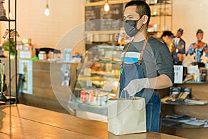 Waiter serving takeaway food to customer in small business social distance conceptual.