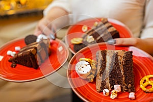 A waiter serving two pieces of pie on plates. He is holding two plates with one hand.