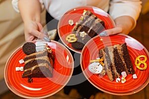 A waiter serving two pieces of pie on plates. He is holding two plates with one hand.