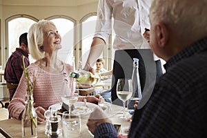 Waiter Serving Wine To Senior Couple In Restaurant